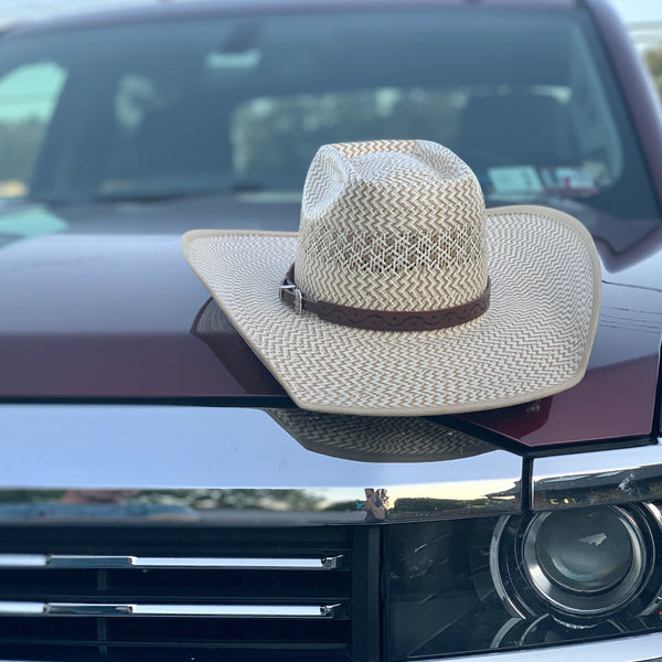 Two S Leatherwork Wave to the Crowd Hat Band on a straw hat, sitting on the hood of a truck.