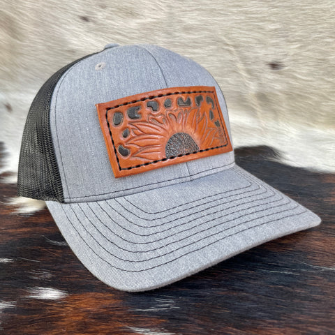 Heather Grey/Black Richardson 112 Trucker Hat with hand carved sunflower and cheerah print patch, hand dyed, and hand stitched. Front.